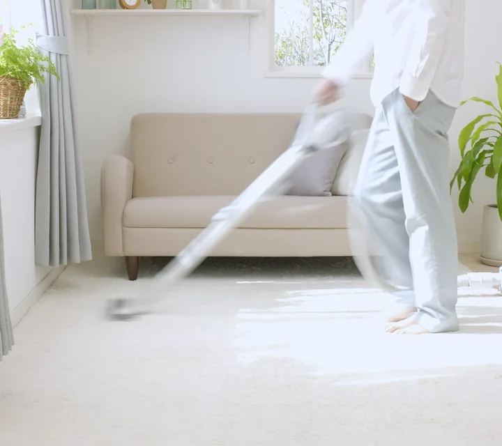 Cleaner vacuuming furniture as a fabric protection service image