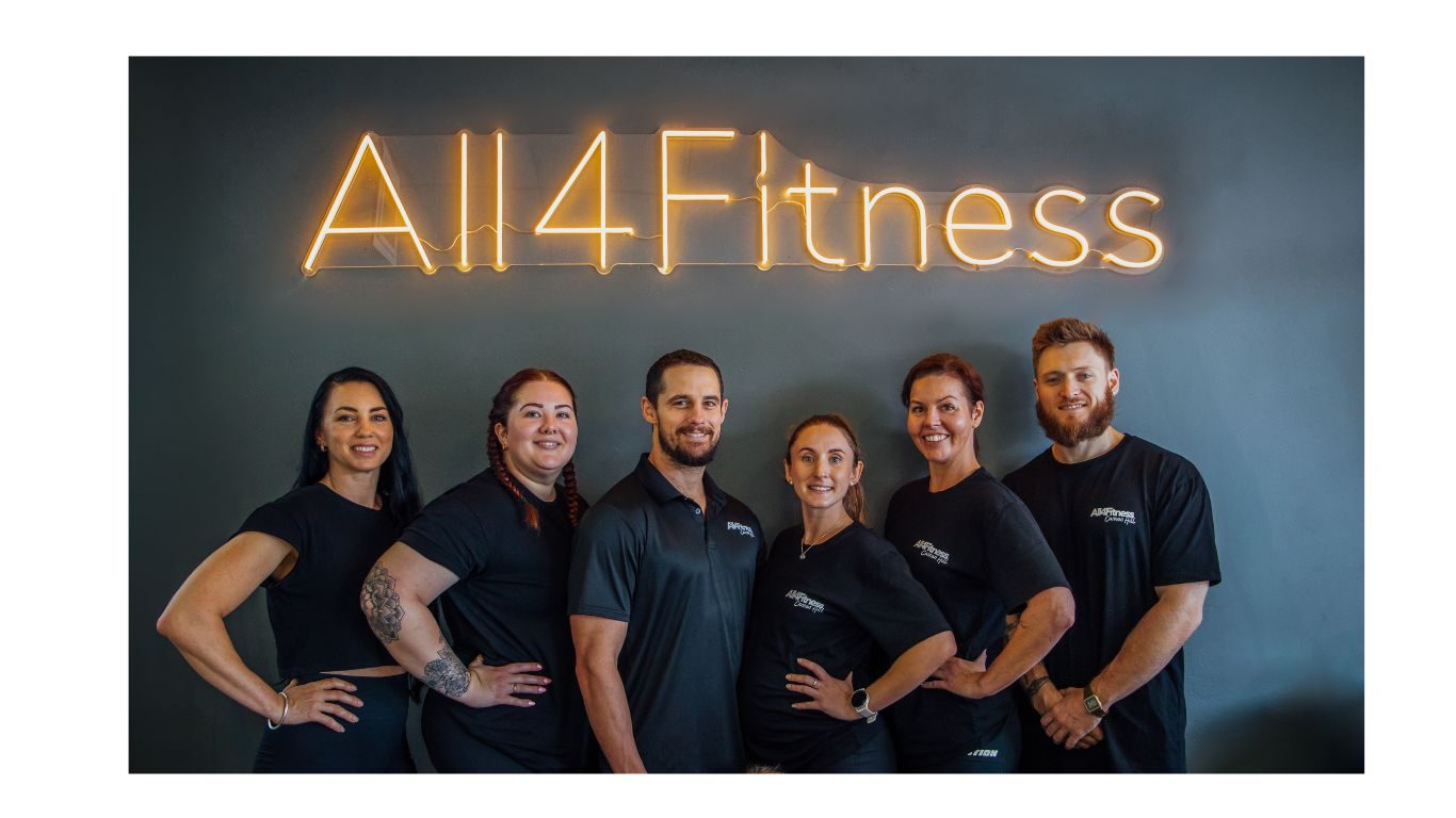 The All4Fitness team in front of the neon sign