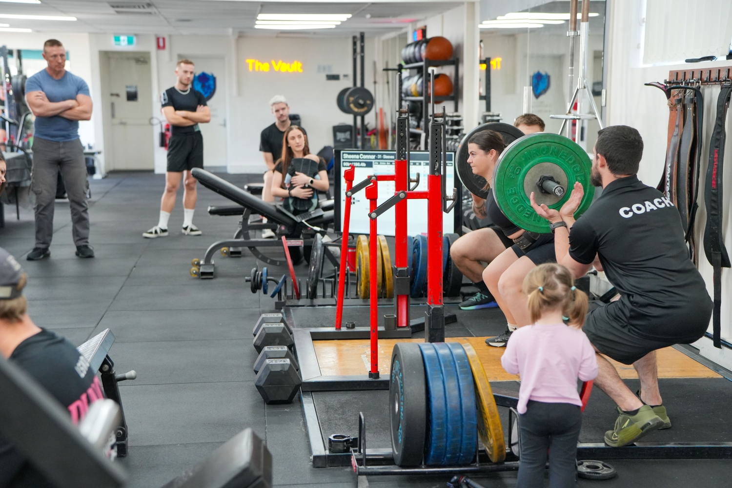 A coach watching a member squat