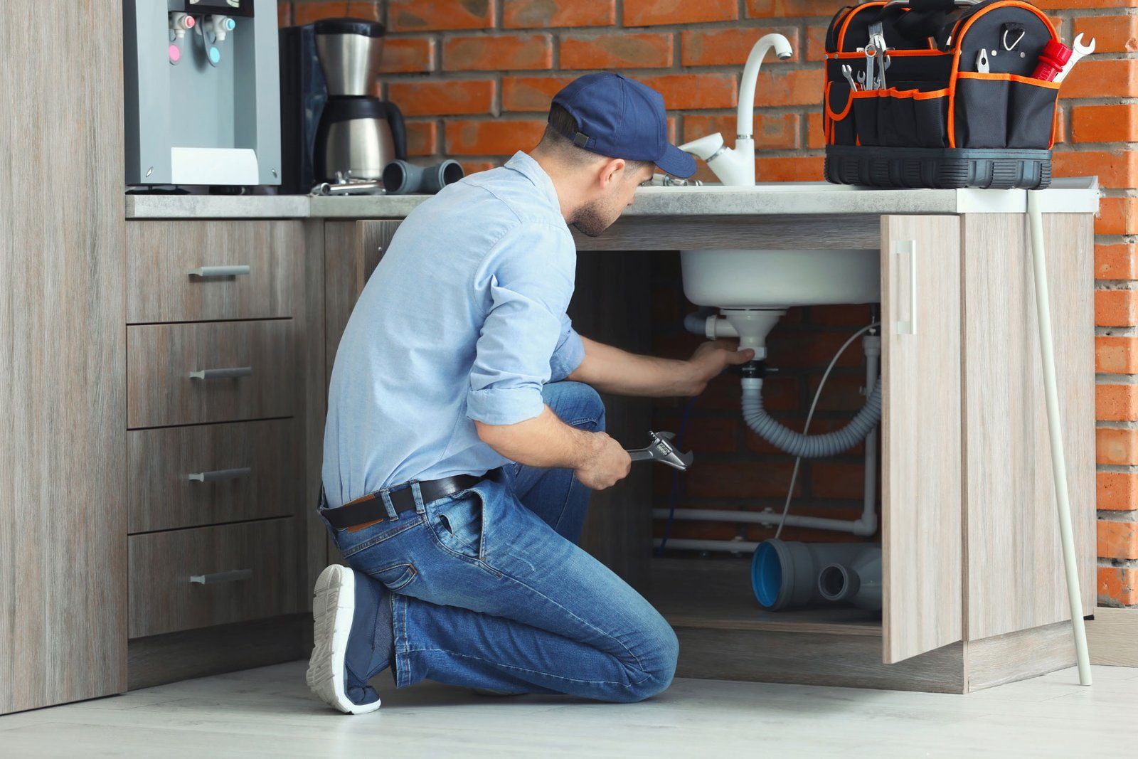 Licensed Atypical Plumber technician repairing a kitchen sink