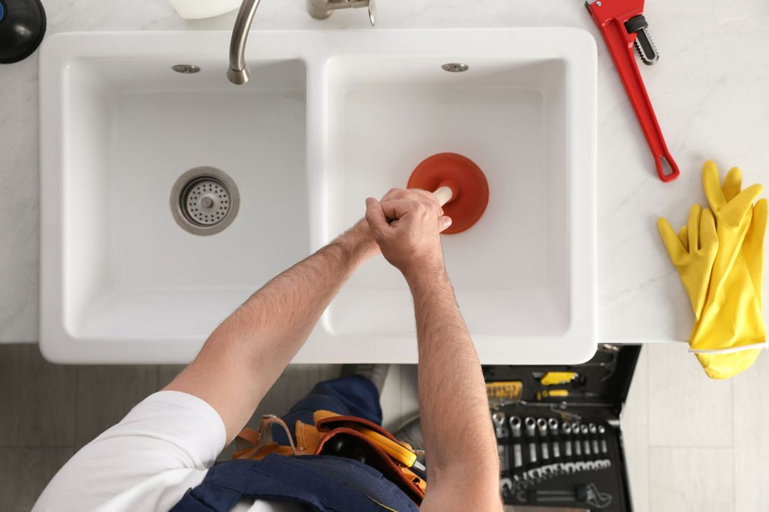 Atypical Plumber diagnosing a plumbing issue