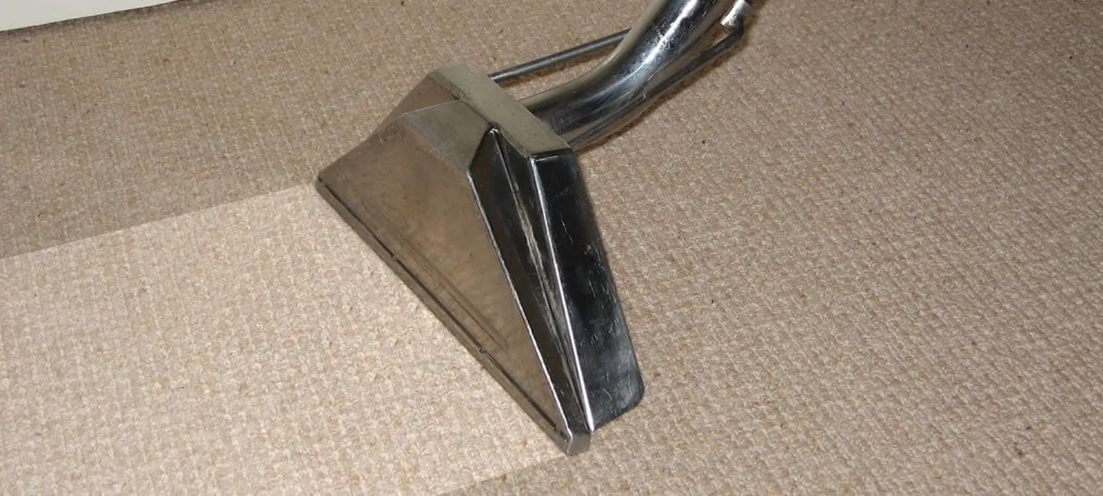 Truck-mount steam cleaning wand deep-cleaning a carpet