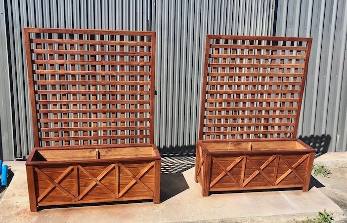 Two timber lattice-back benches against a corrugated metal wall