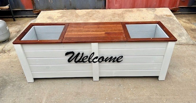 White planter box and seat with glass corner panels and black Welcome text