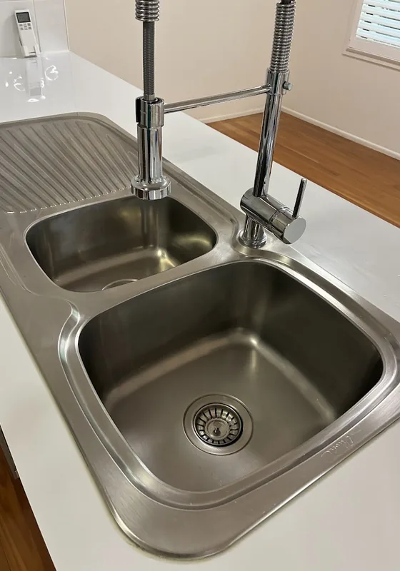 Gleaming stainless steel kitchen sink after cleaning