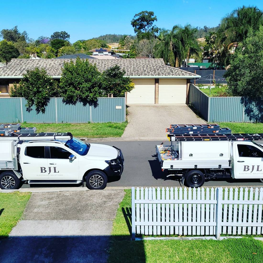 BJL Electrical Solutions service vehicles outside a Brisbane home