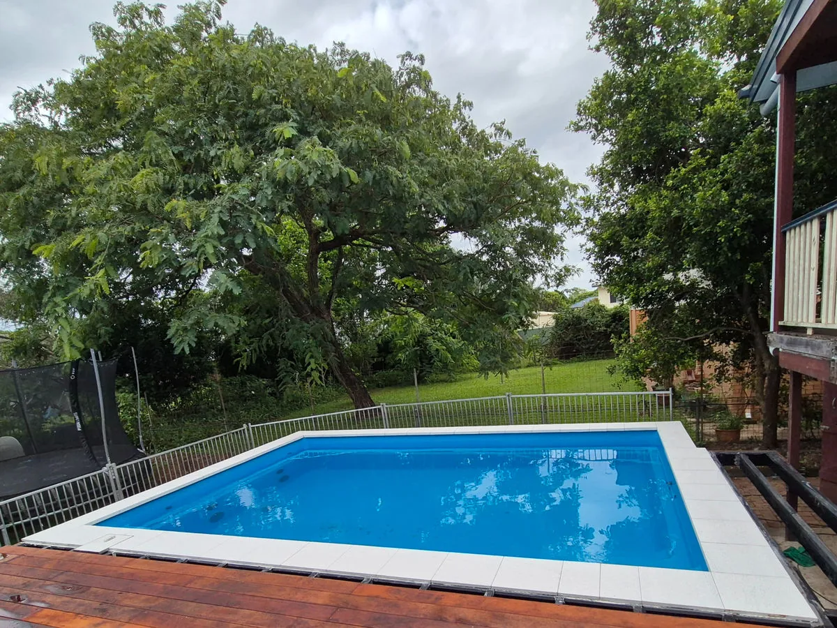 Tiled backyard swimming pool with paved surround