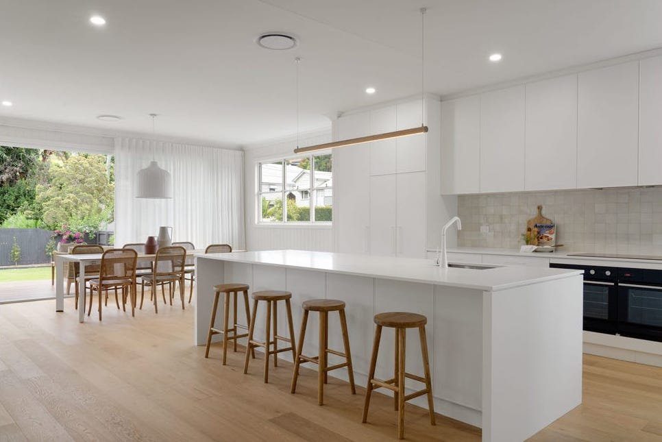 White modern kitchen with island bench and pendant lighting by Briselec