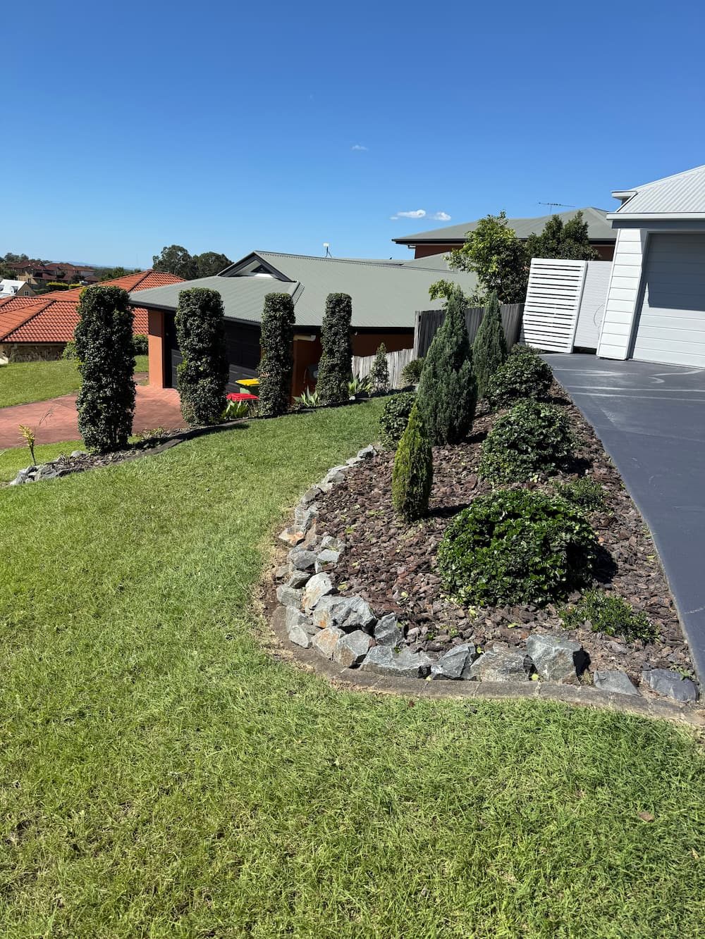 Topiary shrubs and rock-edged front garden