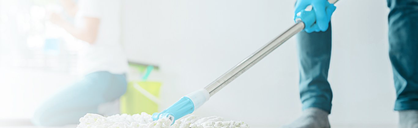 Cleaner mopping a bright interior floor