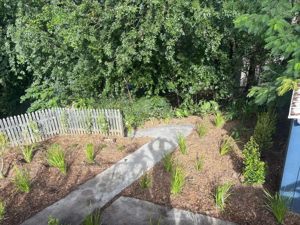 Mulched garden beds and a paved path landscaped by Dawson Landscapes in Brisbane