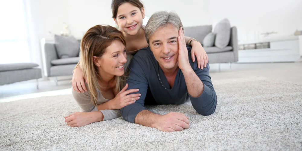 A happy family relaxing on freshly cleaned carpet in their Moreton Bay home