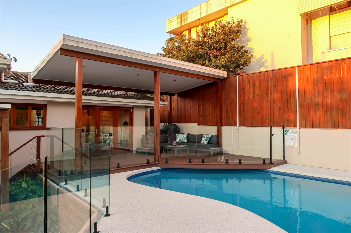 Completed Designer Image landscaping project with pool, deck and glass fencing in Brisbane
