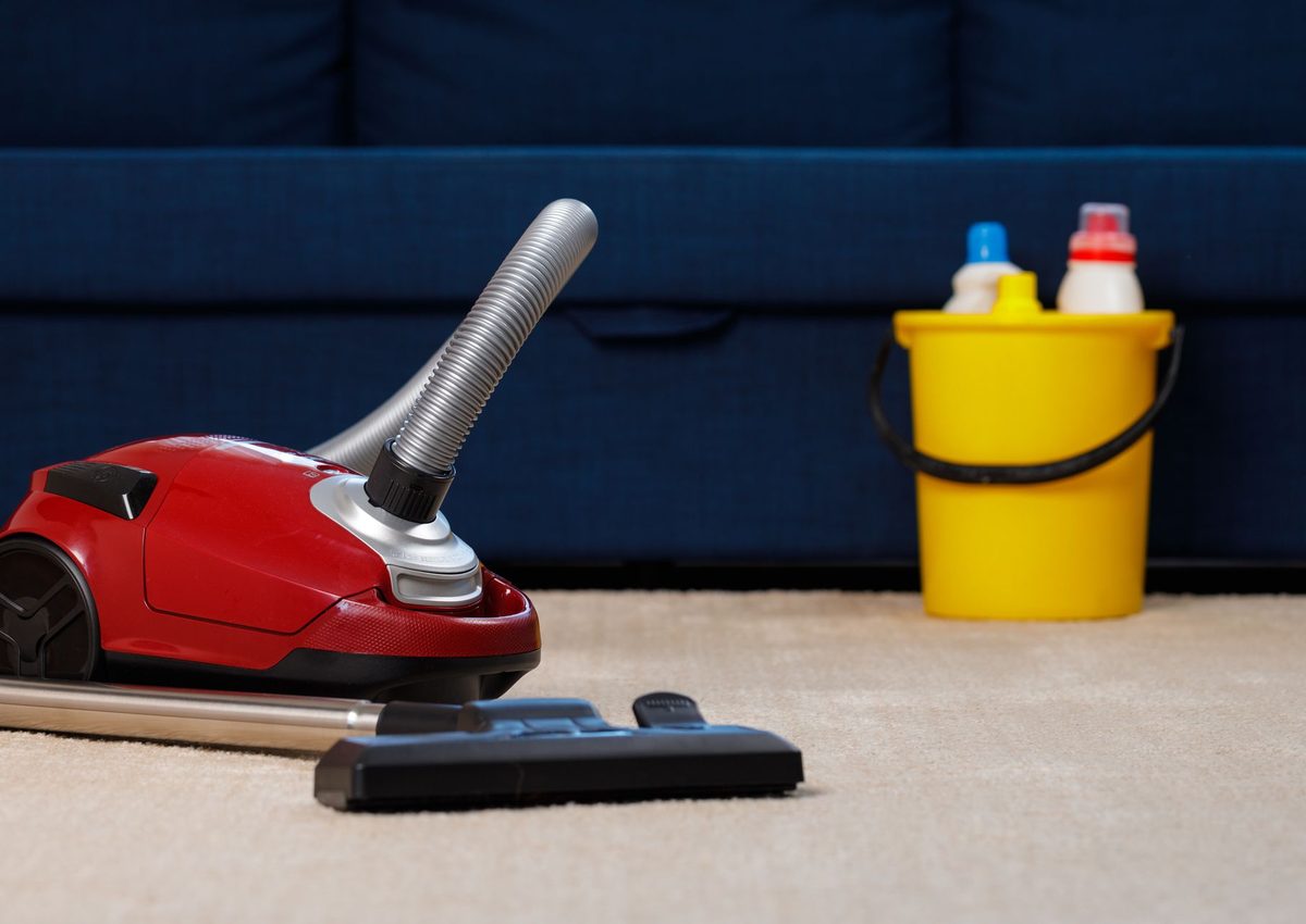 Red vacuum cleaner on beige carpet from source site