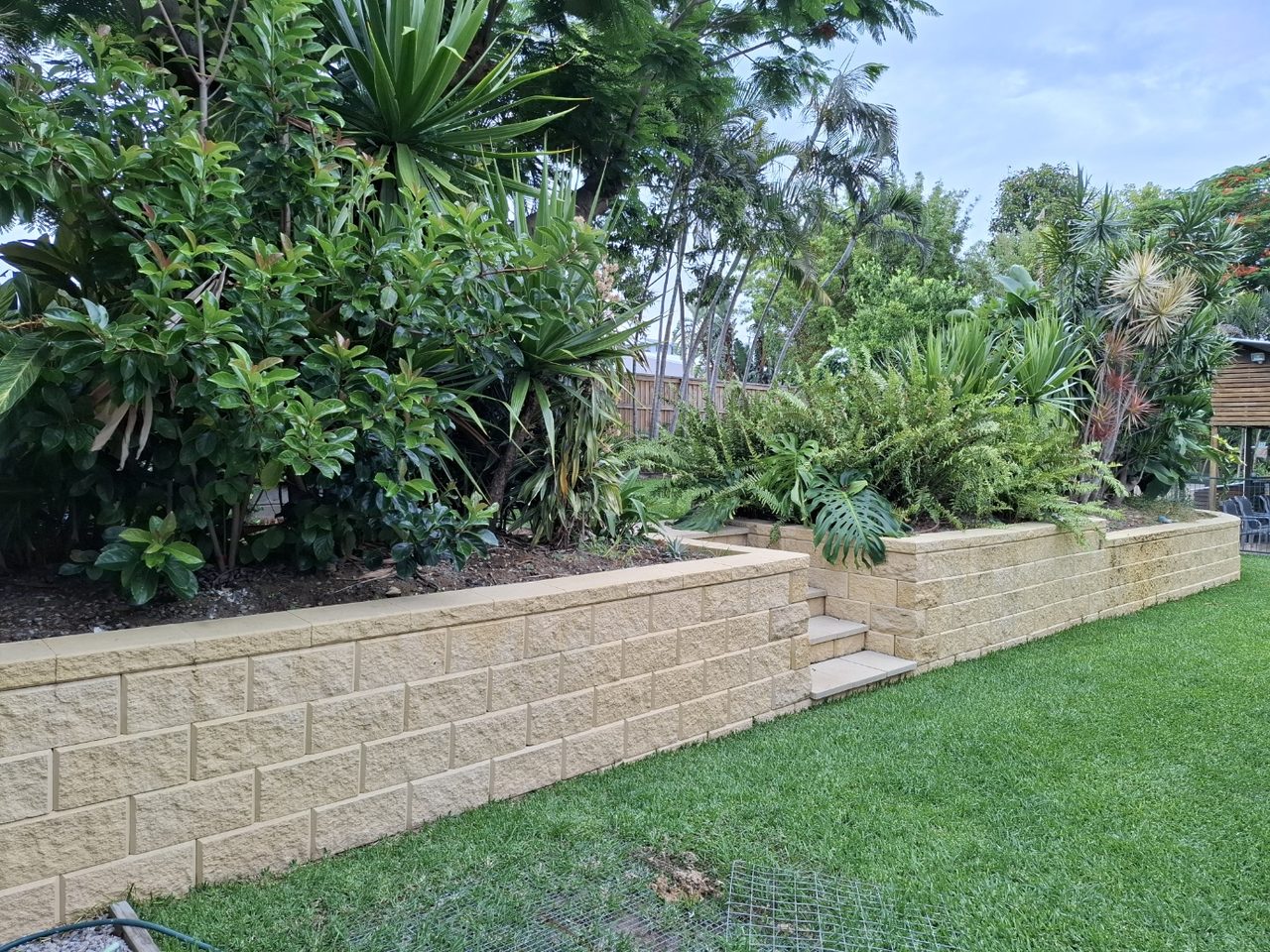 Retaining wall and landscaped yard completed by EZY 4U