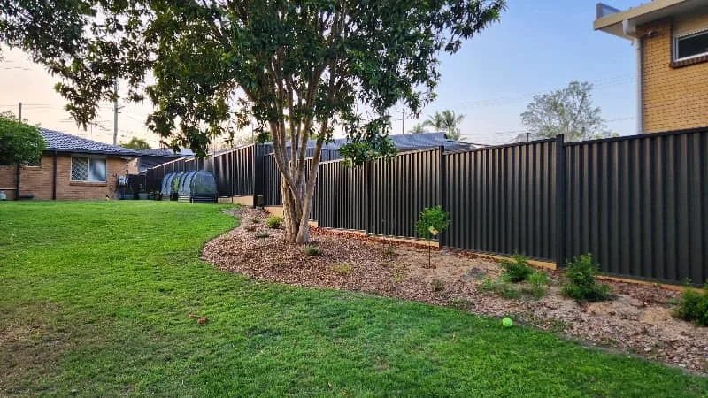 New Colorbond fence with fresh garden beds and turf