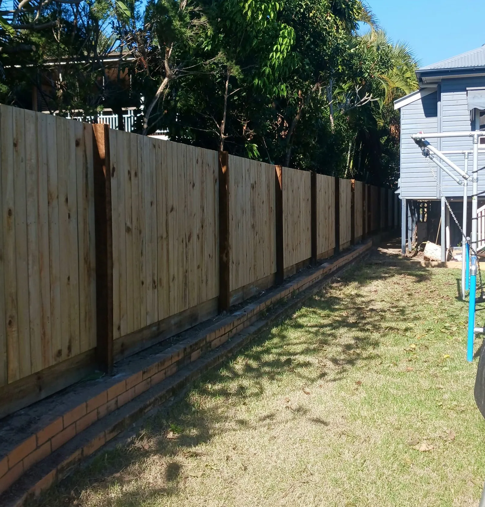 Timber boundary fence on a brick retaining base