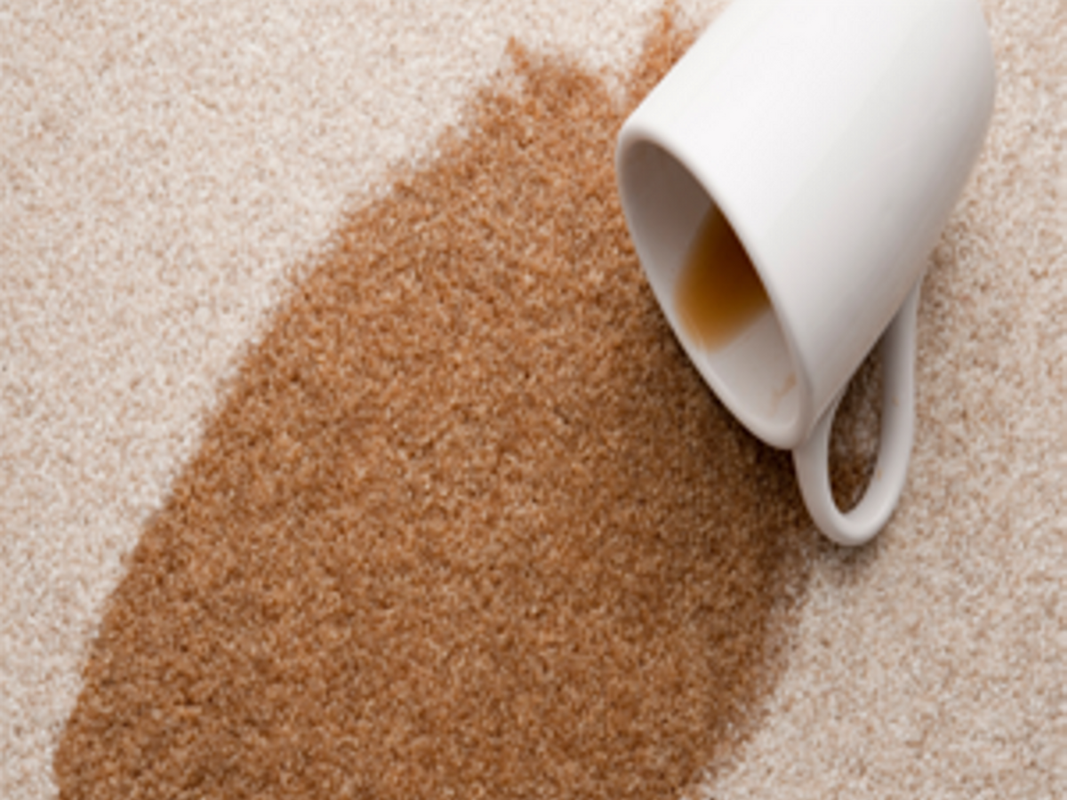A spilled cup of coffee soaking into cream carpet