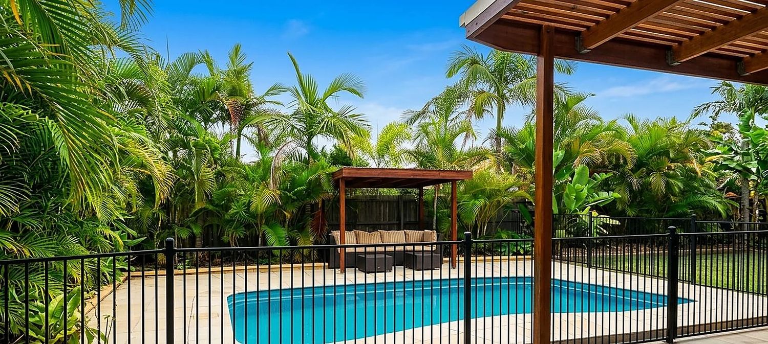 Tropical Queensland backyard with pool, timber pergola and paved outdoor living built by JS Greenbuilders in the Redlands
