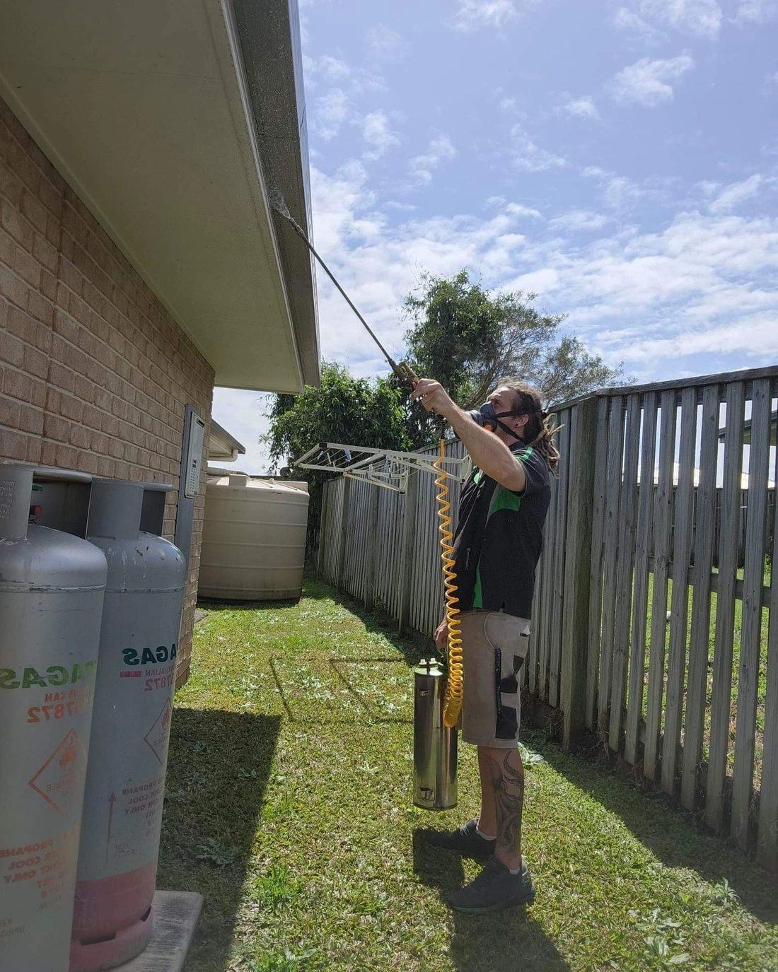 Meansteam technician carrying out a pest control treatment outside a Sunshine Coast home