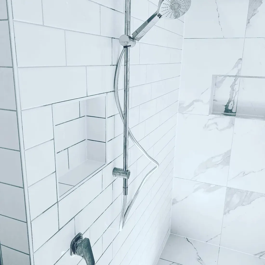 Subway-tiled shower recess with a marble-look feature wall