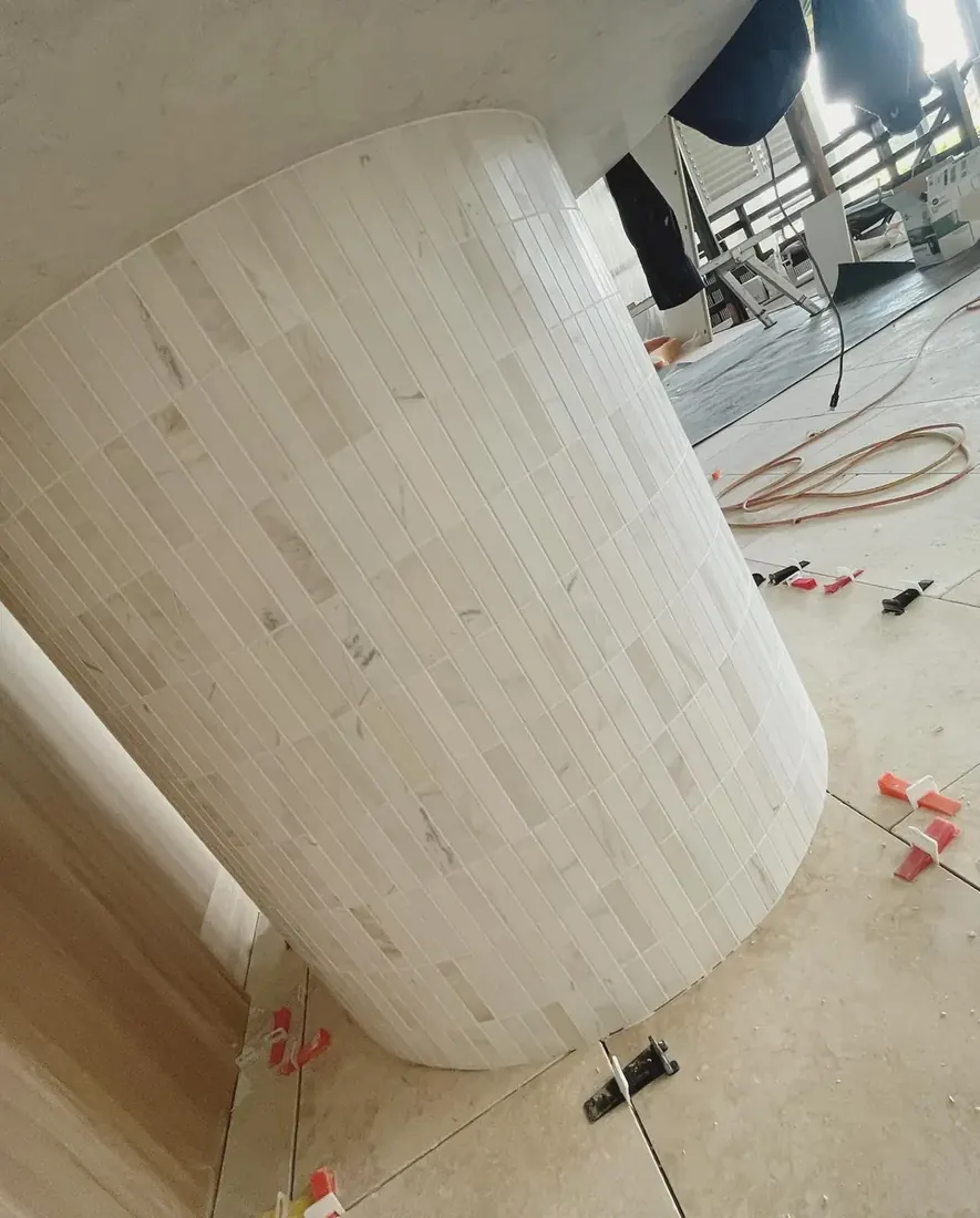 Curved column wrapped in marble mosaic tile