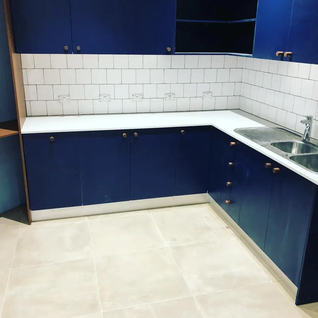 Kitchen with white square splashback tile and large-format floor tile