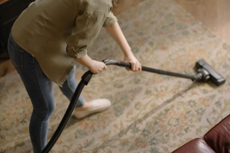 Technician spot-treating a stain on a carpet by hand