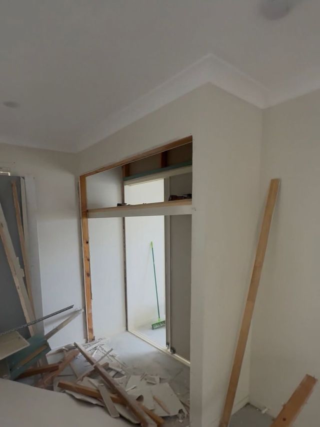 Carpenter repairing door frame at Gold Coast property