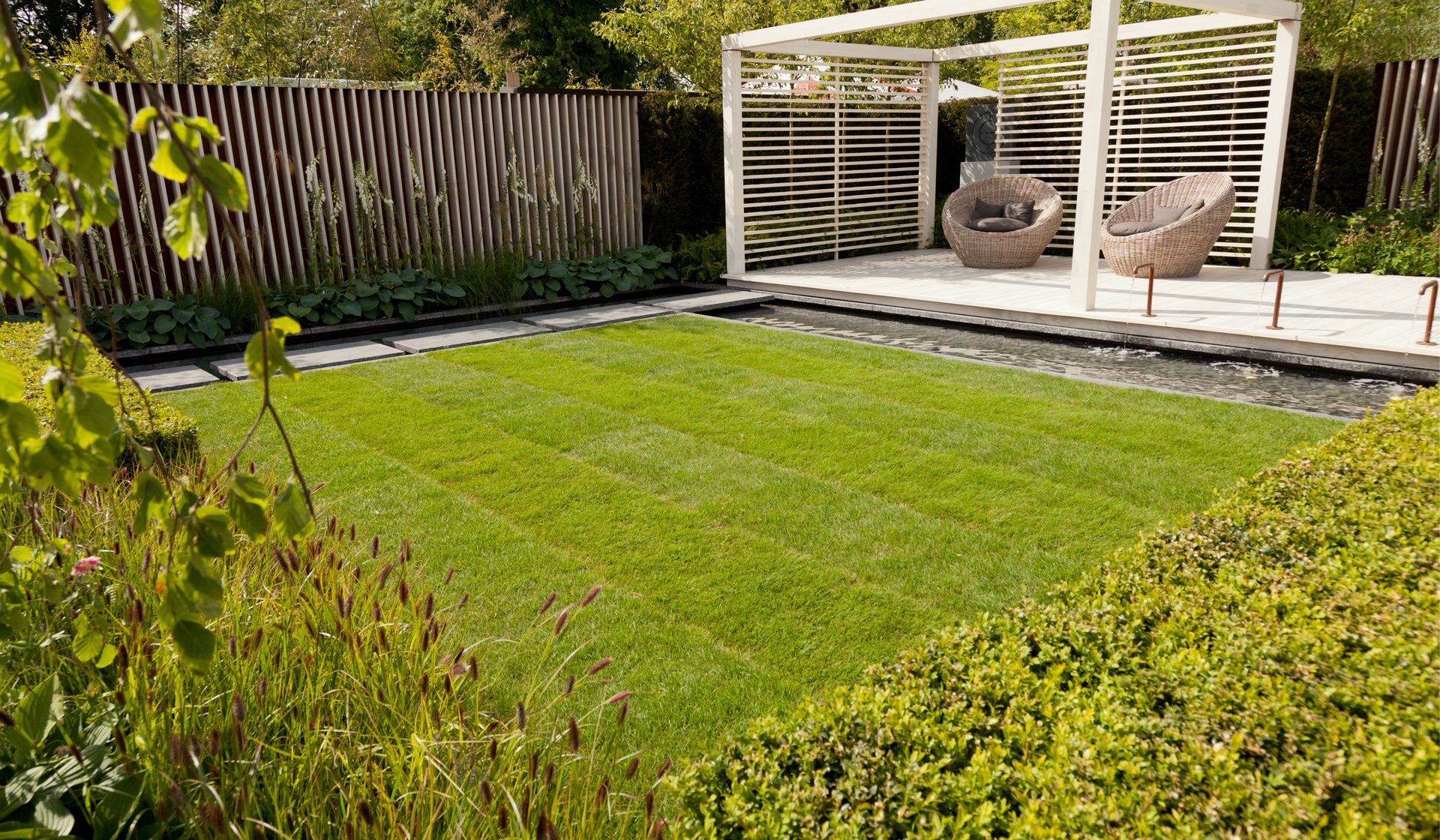 Landscaped garden with paving, lawn and pergola by Revamp Landscapes