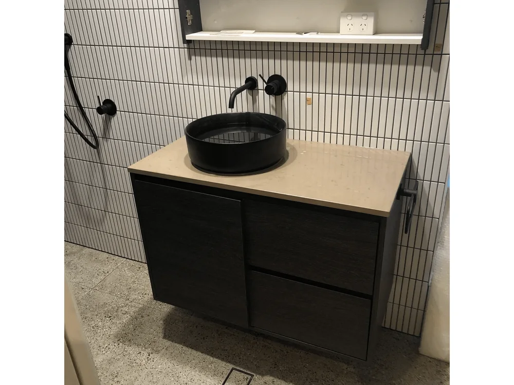 Bathroom vanity with vessel basin and black tapware