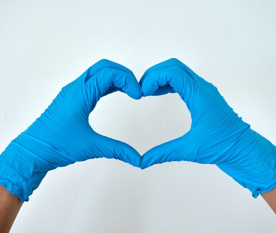 Cleaner in blue gloves forming a heart — Select Cleaning's care for your home