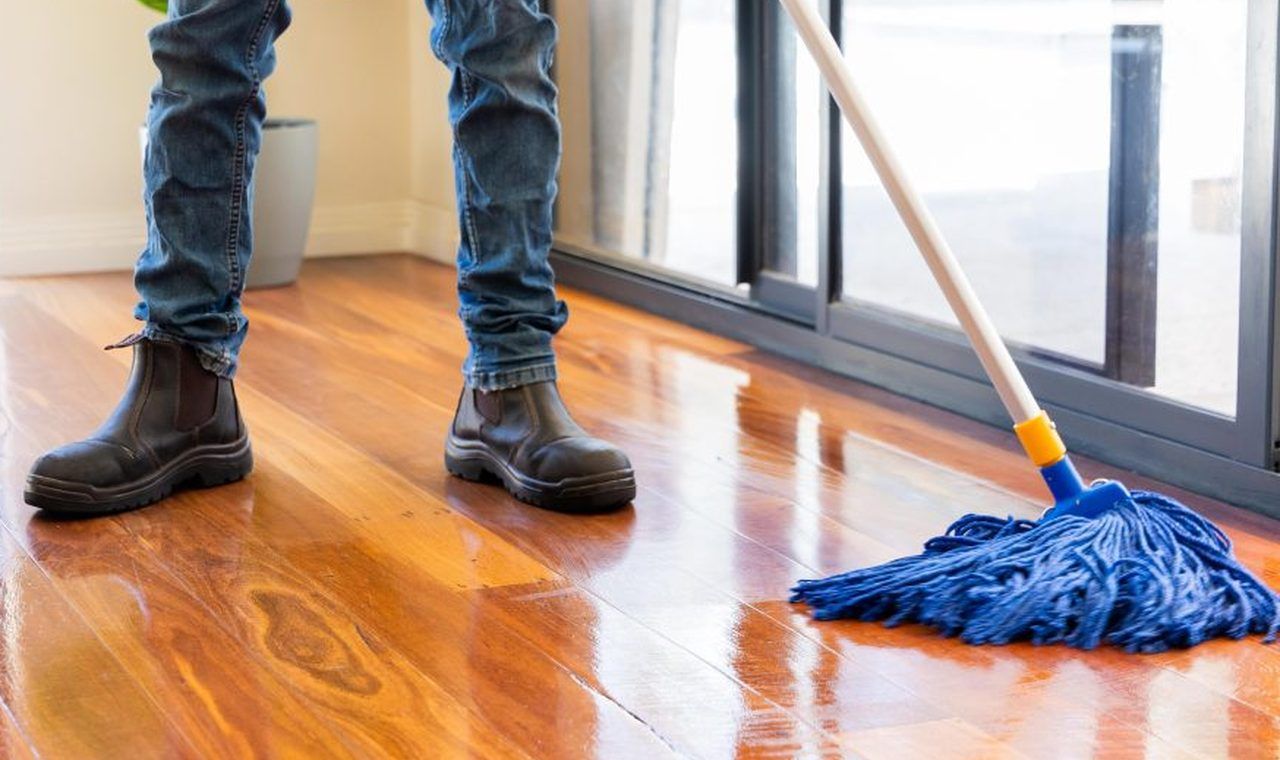 Select Cleaning professional mopping a glossy timber floor in an Adelaide home