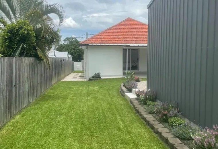 Freshly mowed and edged lawn beside a Brisbane home