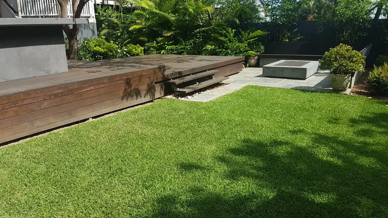 Neatly maintained garden with trimmed greenery beside a deck