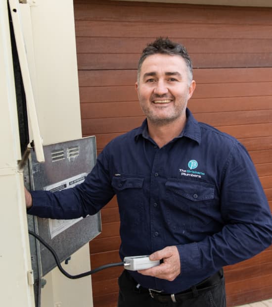 Joseph on site at a Brisbane home, inspecting a hot water system