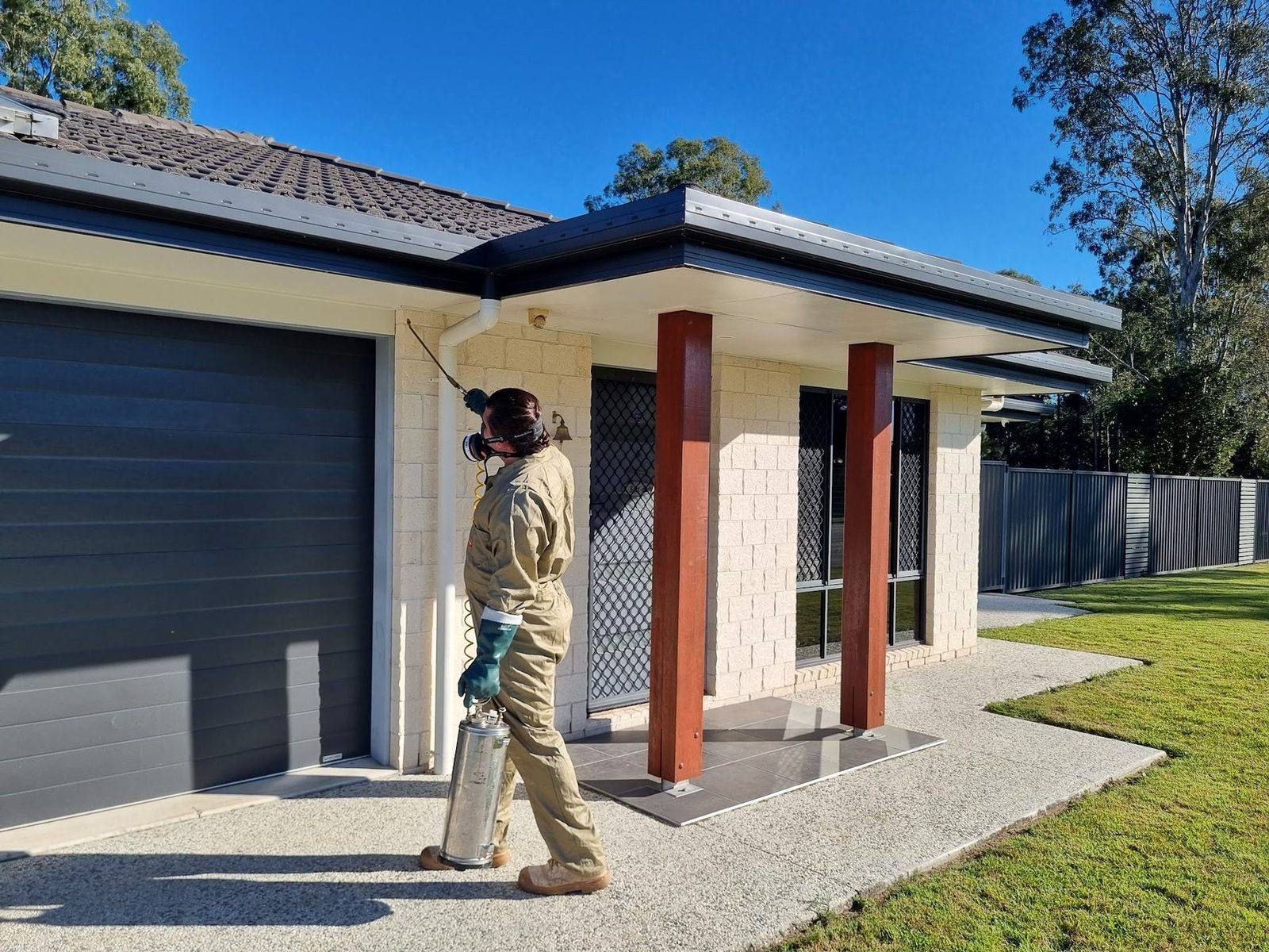 Ticked Off pest control technician treating the exterior of a Caboolture home