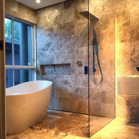 Bathroom tiling with stone-effect wall and shower glass