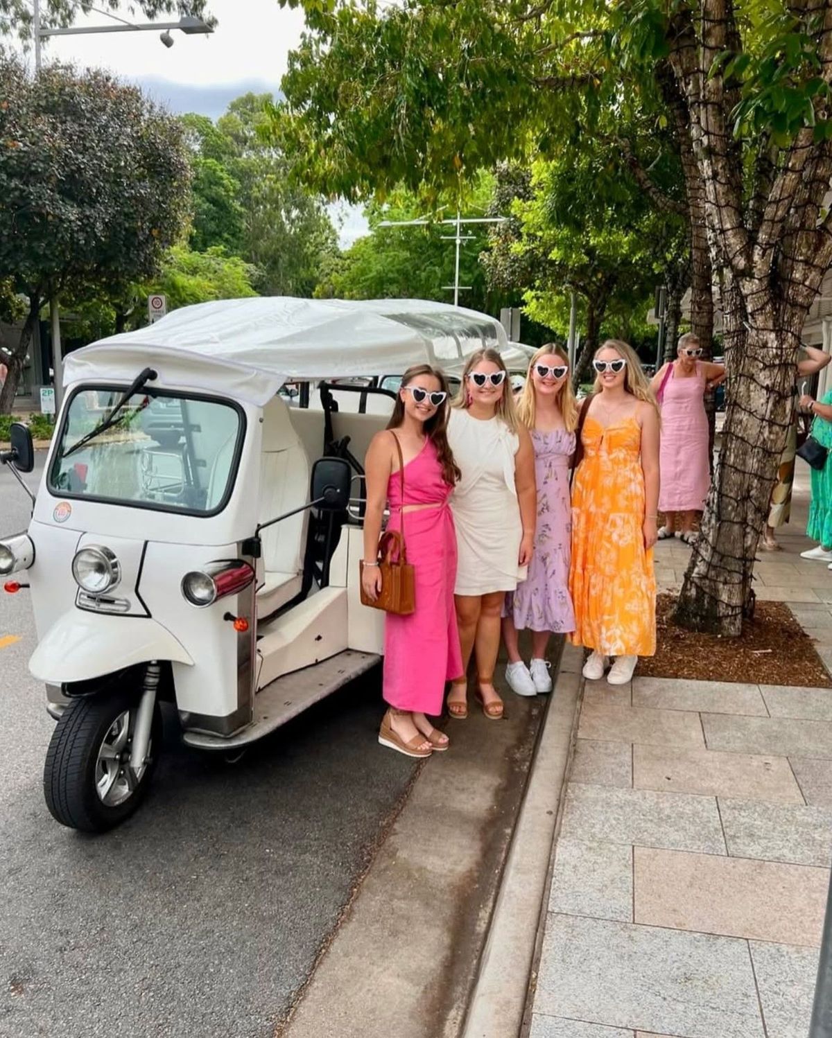 Group celebrating aboard a tuk tuk by the water